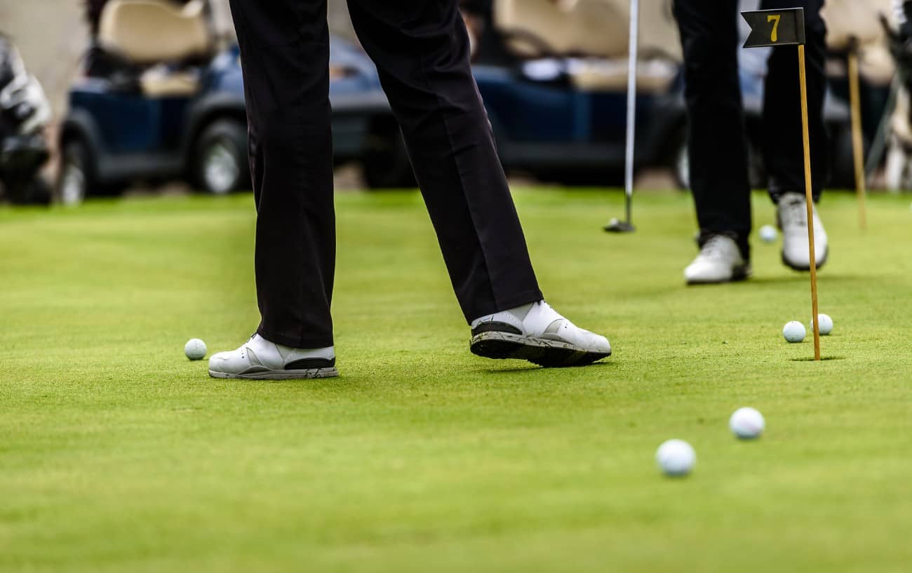 Golf Foot Placement - Your Foot Position for Golf Explained 11 two golfers and a number of balls on a putting green