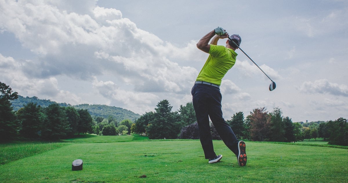 Golfer swinging a club representing the history of the Ryder Cup