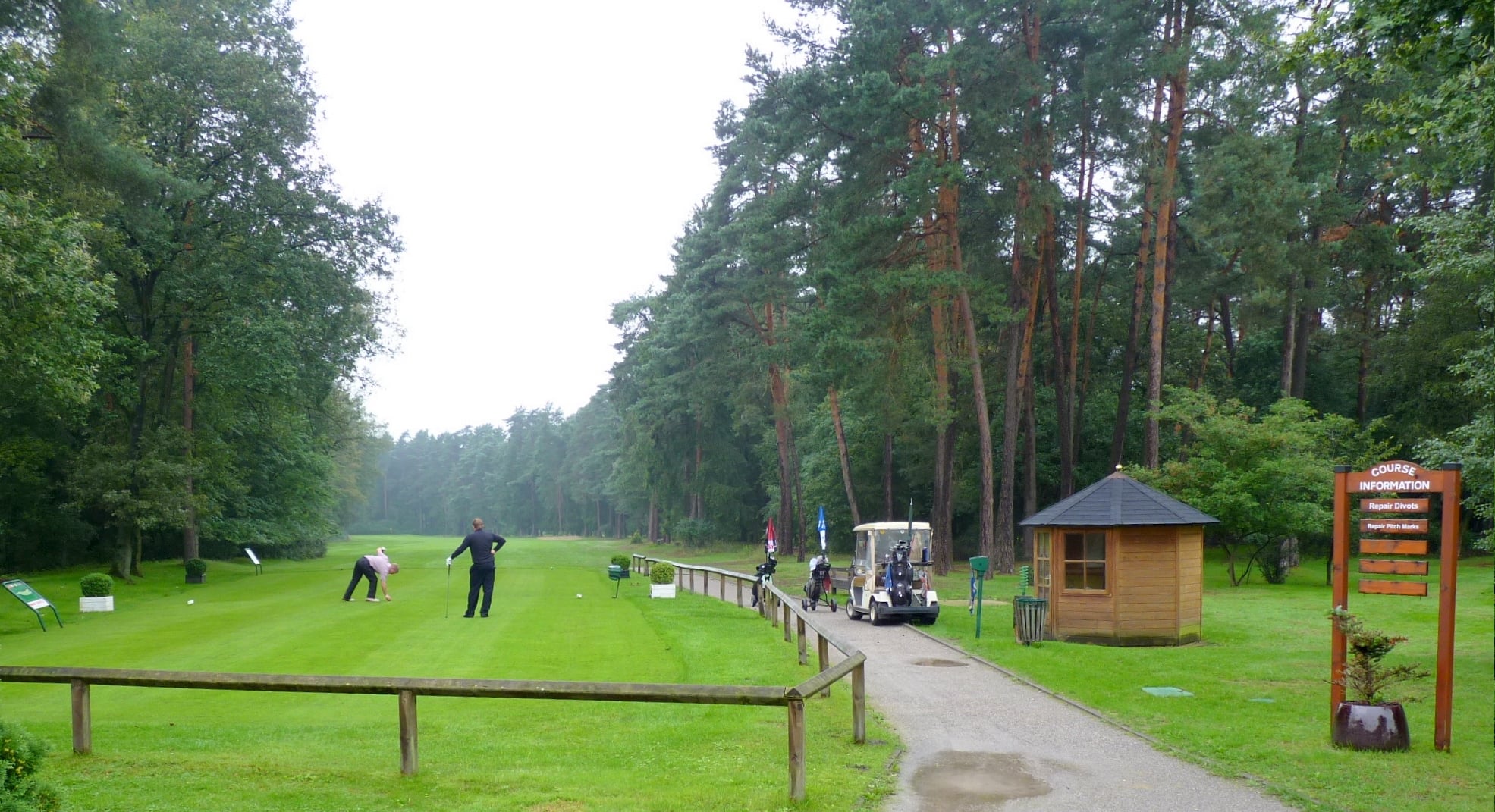 Golfers walking a golf course fairway, illustrating walking golf and electric caddie use in college competition